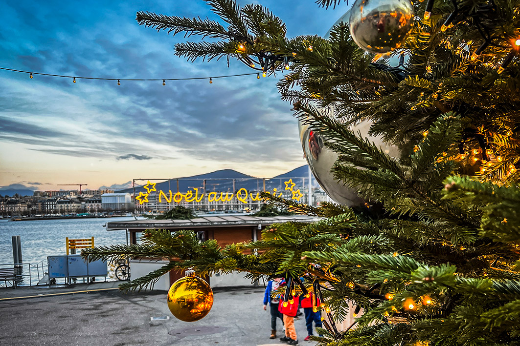 Weihnachtsmarkt Noël au quai in Genf mit festlich geschmückten Ständen und Lichterketten – Teil des Erlebnistrails Finding-Daniel für Gruppen und private Schnitzeljagden.